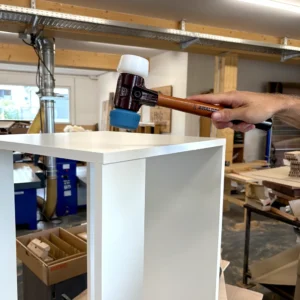 Handwerkerin nutzt den Halder SIMPLEX Schonhammer 50 40 Temperguss an einem Werkstück in der Werkstatt