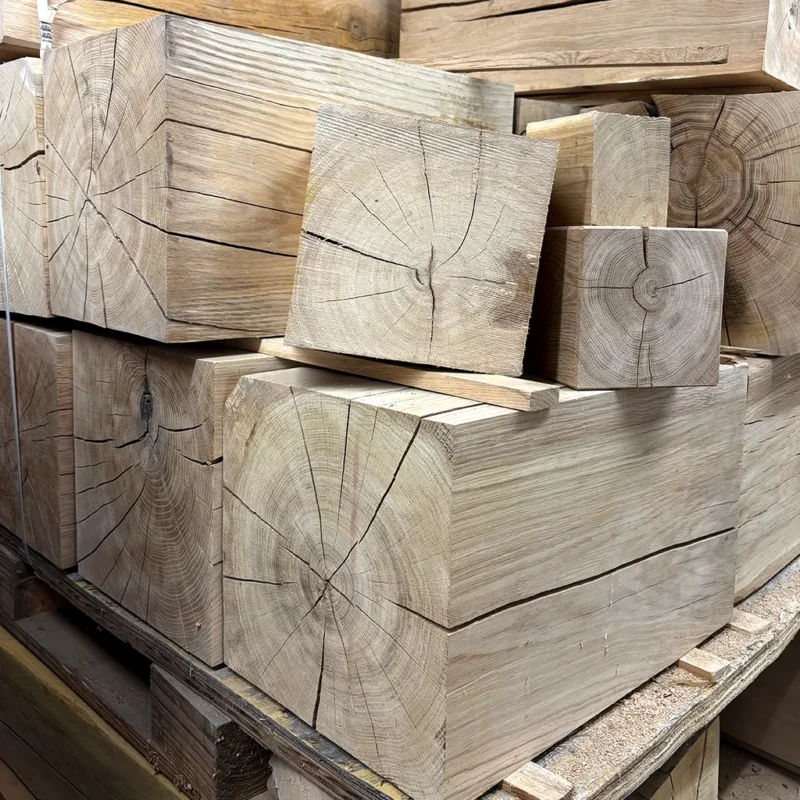 Holzklotz Eiche massiv für DIY Projekte als sägeraue und unbehandelte Rohlinge auf einer Palette in der Schreinerei.