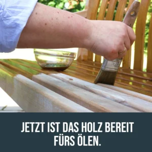 Gereinigte und getrocknete Holz-Gartenbank wird nach der Tiefenreinigung mit einem Pinsel geölt