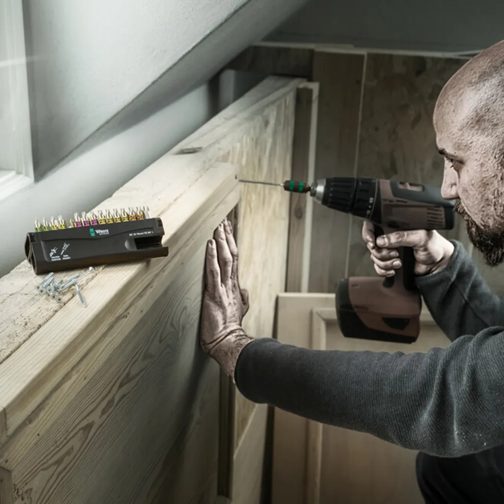 Handwerker verschraubt Holzelemente im Dachausbau mit dem aufgestellten Wera Bit-Check 30 Wood
