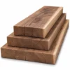 Drei sägeraue und unbehandelte Holzbohlen aus europäischem Nussbaum auf weissem Hintergrund gestapelt, in den Breiten 10 cm, 15 cm und 20 cm.